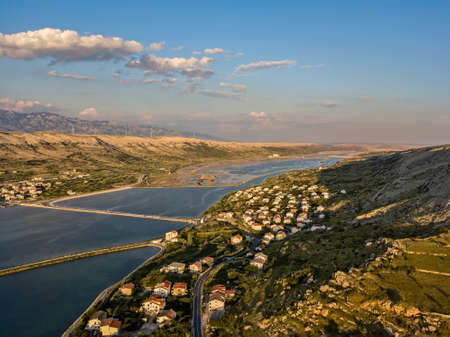 Aerial view of the town of Pag, on the island of Pag, Croatia. Seabed. Panoramic view of the city. Wild and desert nature. Headlands and cliffs of the Croatian coast. Houses on the sea at sunsetの写真素材