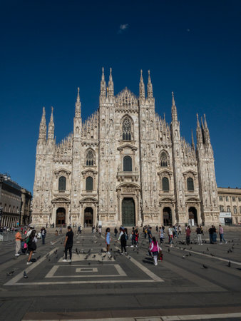 View of the Milan Cathedral and the square. Milan Cathedral. Overview of the facade of the cathedral in white marble. Buttresses, pinnacles and spiers. Statue of the Madonnina. Lombardy. 05-20-2021.のeditorial素材