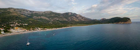 Aerial view of Jaz Beach promontory in the background. Budva. Montenegro. Catamaran. Jagged coasts with sheer cliffs overlooking the transparent sea. Wild nature and Mediterranean maquisの写真素材