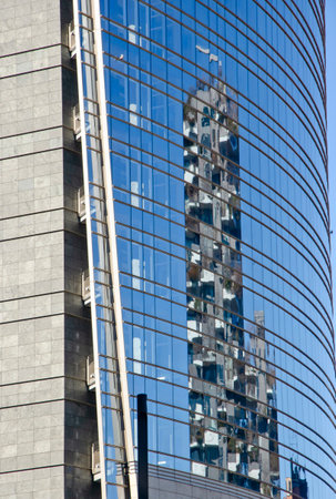 Architecture. Design of buildings in the heart of Milan. Skyscrapers and buildings in Piazza Gae Aulenti. Unicredit tower and Bosco Verticale reflected in the mirrored glass of the tower. 02-02-2022.のeditorial素材