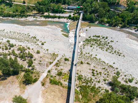 Aerial view. Drought and dry rivers. Roman bridge of Bobbio over the Trebbia river, Piacenza, Emilia-Romagna. Italy. River bed with stones and vegetation. Called hunchback bridgeの写真素材