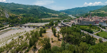 Aerial view. Drought and dry rivers. Roman bridge of Bobbio over the Trebbia river, Piacenza, Emilia-Romagna. Italy. River bed with stones and vegetation. Called hunchback bridgeの写真素材