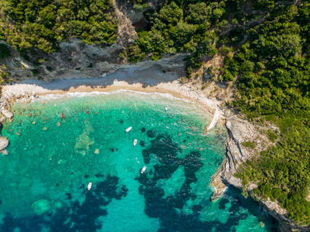 Aerial view of Kolias Beach on the island of Corfu. Greece. Cliffs overlooking the beach and an uncontaminated green and blue sea. Moored boatsの写真素材