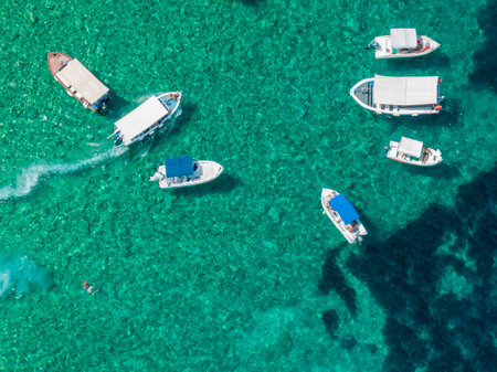 Aerial view of boats close to Limni Beach Glyko, on the island of Corfu. Greece. Where the two beaches are connected to the mainland providing a wonderful scenery. Unique double beのeditorial素材