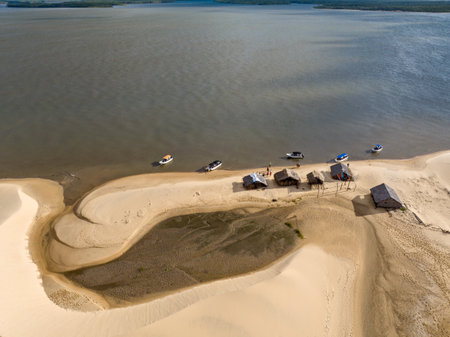 Aerial view of Parque da Dunas - Ilha das Canarias, Brazil. Huts on the Delta do ParnaÃ­ba and Delta das Americas. Lush nature and sand dunes. Boats on the river bankの写真素材