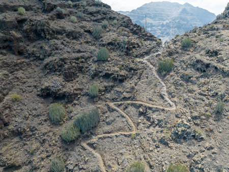 Aerial view of the trail through the mountains to Guigui beach, pristine black sand beach, Gran Canaria. Spain. Scenic trailの写真素材