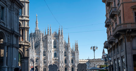 View of the Milan Cathedral and the square. Duomo di Milano. Overview of the facade of the cathedral in white marble. Buttresses, pinnacles and spiers. Statue of the Madonninaの写真素材