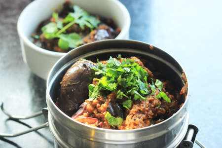 Brinjal vegetable, packed in a lunch box Indian style. Garnished with coriander.の写真素材