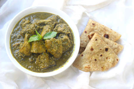 Hariyali green chicken with roti or naan. Served in a white bowl and white background.の写真素材