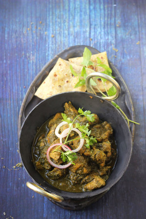 Hariyali green chicken with roti or naan. Served in a white bowl and white background.の写真素材