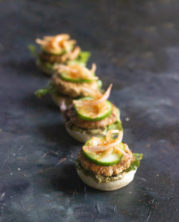 Open chicken sliders with moist juicy chicken patty, onions, mayo and pickled onion on the side on a black backgroundの写真素材