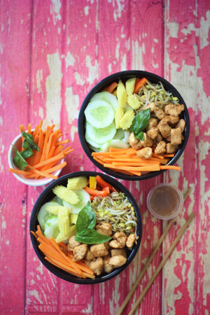 Grilled chicken salad with fresh vegetables, carrots, sweet potato, and dressing on the side.の写真素材