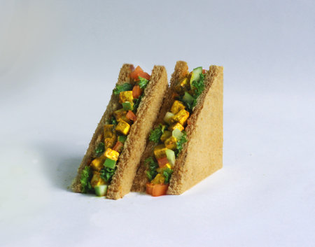 Mint paneer (cottage cheese) healthy salad sandwich on brown bread with fresh greens, tomatoes, and lettuce.の写真素材