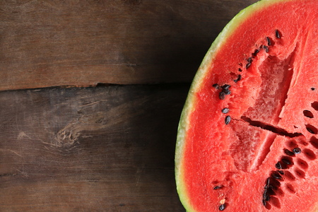 Cut in half watermelon on wooden table backgroundの写真素材