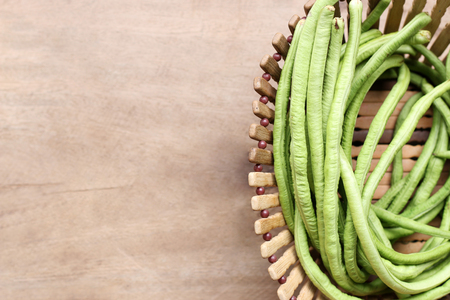 yard long bean in basket on wooden table backgroundの写真素材
