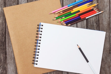 Blank paper and colorful pencils on the wooden tableの写真素材
