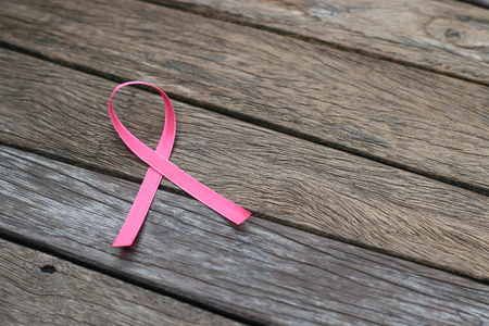 healthcare and medicine concept. pink breast cancer awareness ribbon on wood table.の写真素材