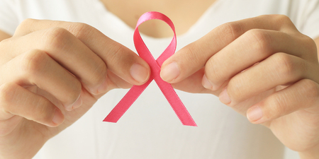 healthcare and medicine concept. Woman hand holding pink breast cancer awareness ribbon.の写真素材