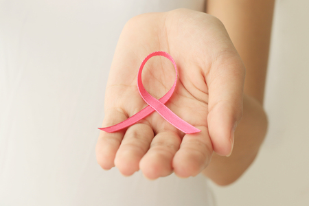 healthcare and medicine concept. Woman hand holding pink breast cancer awareness ribbon.の写真素材
