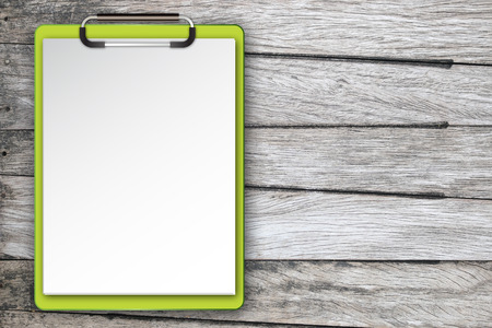 Clipboard with a sheet of paper on wooden tableの写真素材