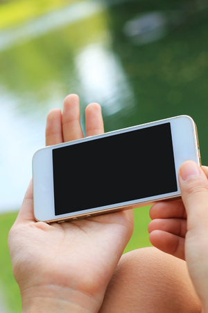 Hand holding smartphone with blank screenの写真素材