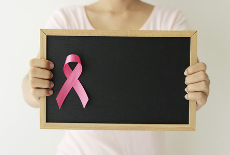 healthcare and medicine concept. Woman hand holding pink breast cancer awareness ribbon.の写真素材