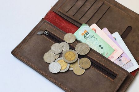 Thai money in Brown leather wallet on white backgroundの写真素材