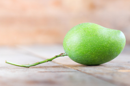Green mango fruit on wooden backgroundの写真素材