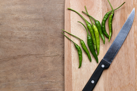 Green peppers on a kitchen cutting boardの写真素材
