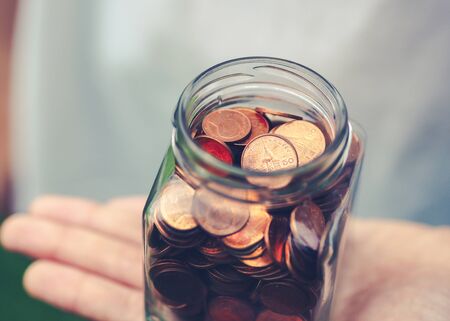 Woman holding jar of coins. Saving Money concept.