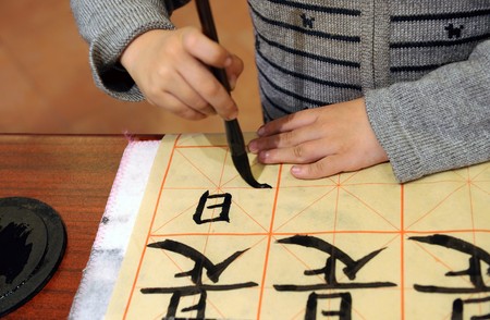 Boy in China learning to write Chinese calligraphyの写真素材