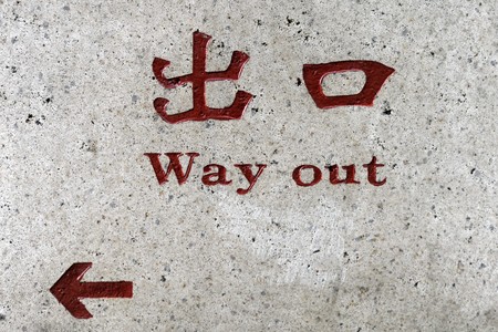 Way out Sign on wall-- in Chinese and English in red letters and charactersの写真素材
