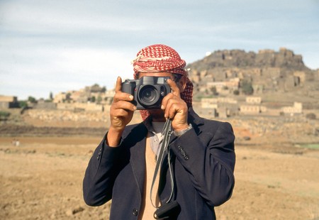 Arab man with veil, in Yemen, taking photograph の写真素材