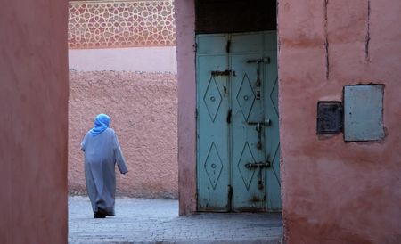 Moroccan woman in djellaba walking in Marrakesh's medinaの写真素材