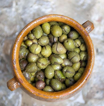 Green olives with waterdrops in a stone pot 
の写真素材