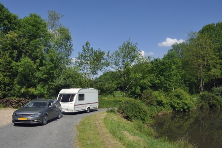 Caravan passing a small lake at a campsite in Franceの写真素材