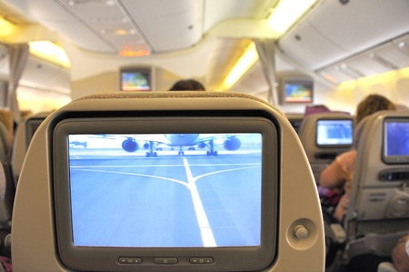 Airplane Interior with entertainment monitor in the seat showing the front view in the cockpitのeditorial素材