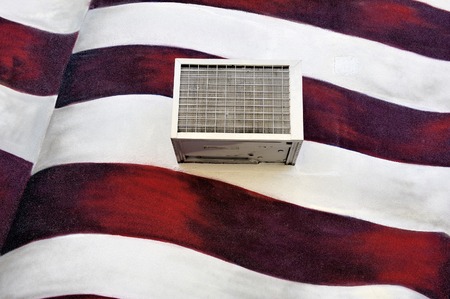 New York, USA-November 11, 2012; Air-condition unit mounted outside against a wall that is painted with the American flag  November 11, 2012 New York City, USAのeditorial素材