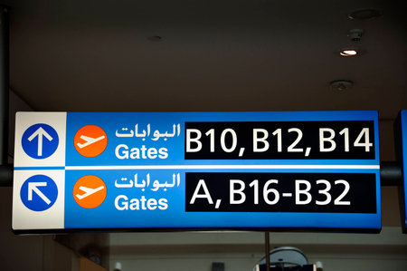 Dubai, United Arab Emirates-February 10, 2014 English Arabic Airport Signs showing the directions to the gates at the Dubai International Airport February 10, 2014, Dubai, United Arab Emiratesのeditorial素材