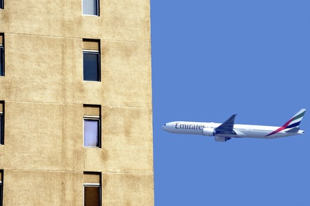 Dubai, United Arab Emirates-February,10,2014;Airplane of Emirates Airline is taking of near apartment buildings in the city of Dubai. February 10,2014 Dubaiのeditorial素材