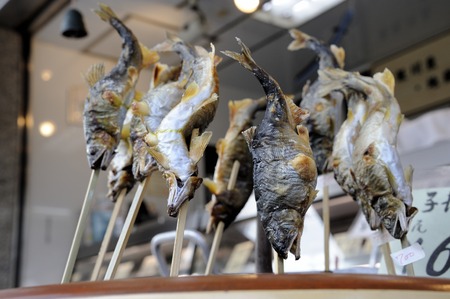 Fried fish at a market booth of a vender at the food market. Selective focus at the fish in the middle.の写真素材