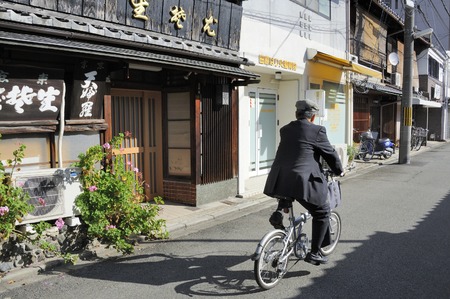 Kyoto, Japan-November 3, 2014; Man cycling at a street in Kyoto midtown .November 3, 2014 Kyoto, Japanのeditorial素材