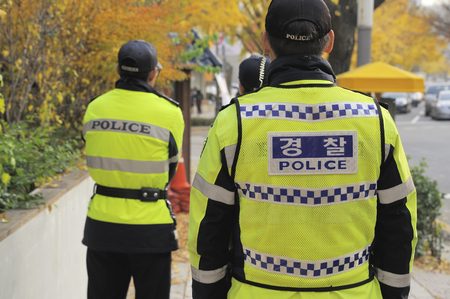 Seoul, South Korea- Three policemen seen from the backside at a street in Seoul.の写真素材