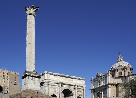 The Column of Phocas, Forum Romanum, Rome, Italy. On the right, Arch of Septimius Severus and the facade of the Church of Saint Luke and Martina.の写真素材