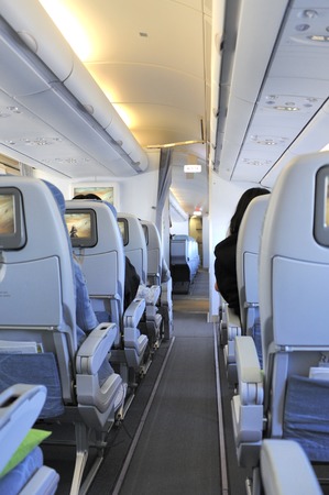 Passengers in the tourist class sitting in their seats of the airplaneのeditorial素材