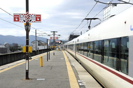 OSAKA, JAPAN- NOVEMBER 05, 2014: Railway platform in Japan with train ready to leave. Signs with text in English and Japanese count the passengers on the platform is the emergency buttonのeditorial素材