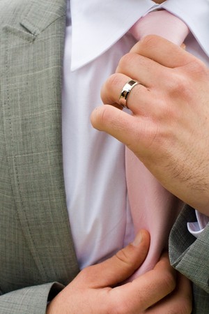 Ascertive man checking his tie with a business suit.の写真素材