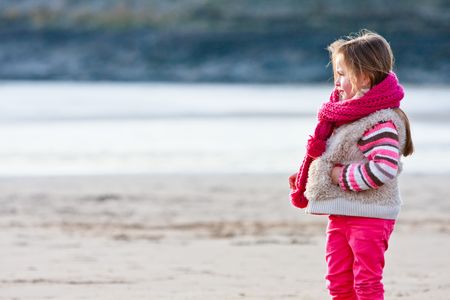 Young girl on the beach alone during Autumn in Englandの写真素材