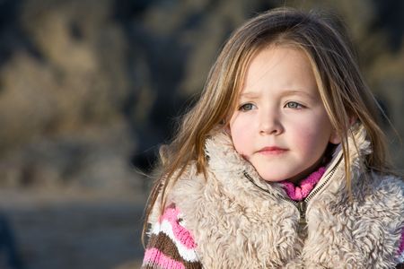 Young girl on the beach alone during Autumn in Englandの写真素材