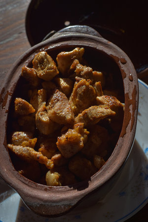 Chinese food, fried pork skin in clay pot on wooden table.の写真素材